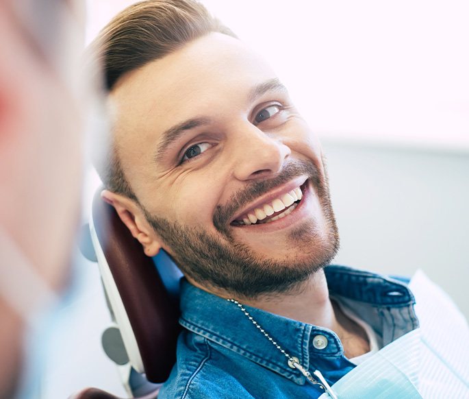 Man smiling while sitting in treatment chair