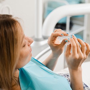 Patient holding clear aligner in treatment chair