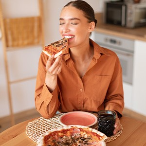 Woman enjoying meal in kitchen at home