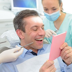 A man looking at his teeth in a mirror