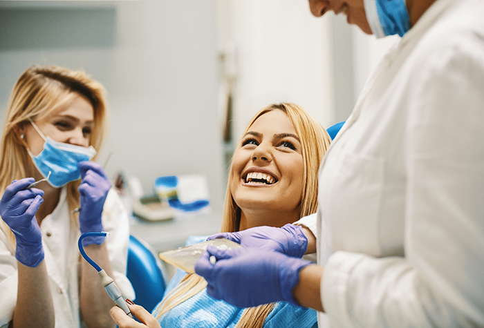 Woman in dental chair grinning up at her dentist in Salmon Creek