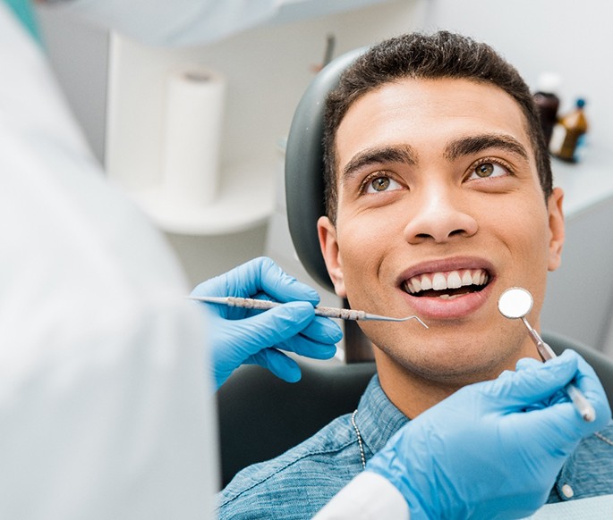 Man in denim shirt about to undergo dental exam