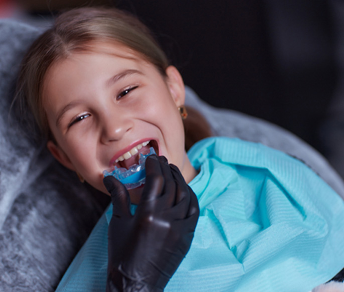 Girl receiving mouthguard for athletics