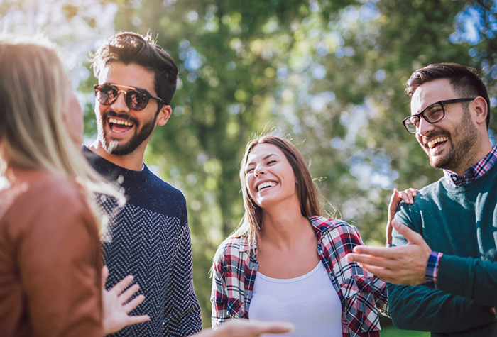 Four adults laughing together outdoors after cosmetic dentistry in Salmon Creek