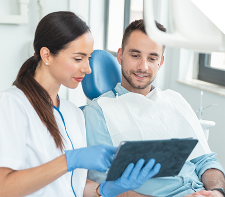 Dentist showing a tablet screen to a patient