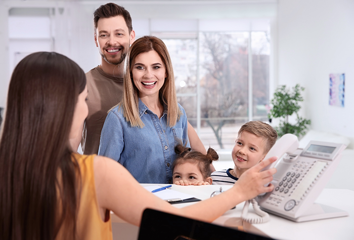 Family of four checking in at dental office front desk