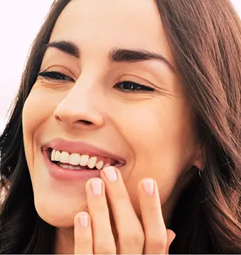 Smiling woman touching her face