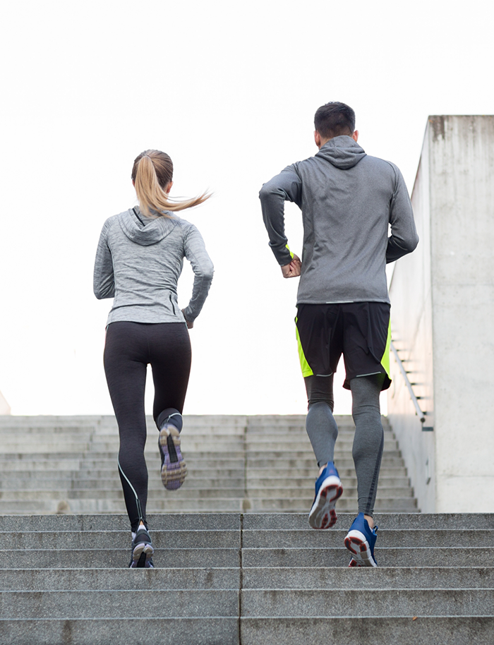 Man and woman jogging up a staircase