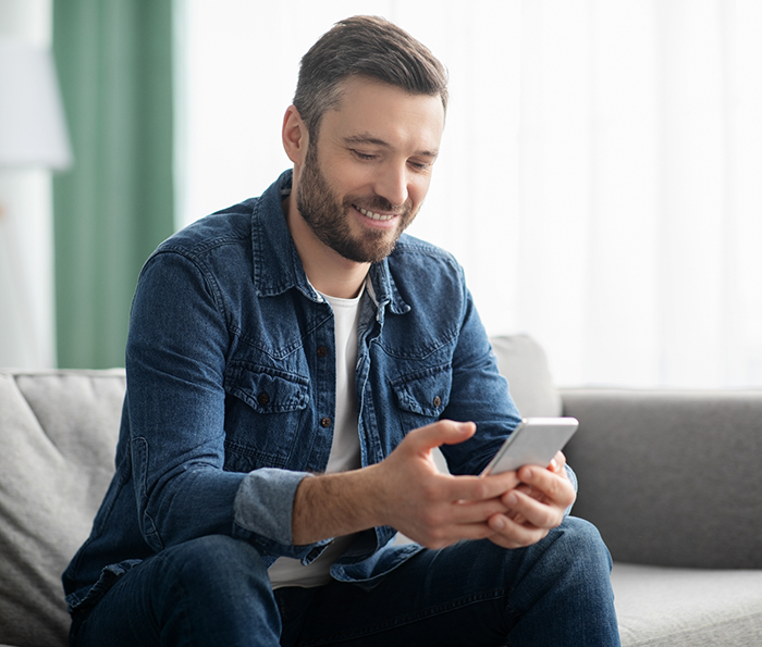 Man smiling while looking at his phone
