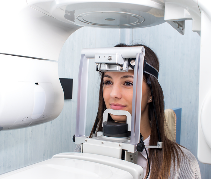 Woman getting a cone beam scan of her mouth and jaw in dental office