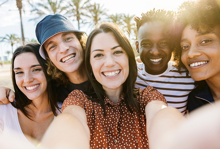 Selfie of five young adults smiling outdoors