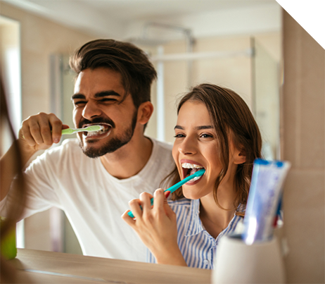 Man and woman brushing their teeth together